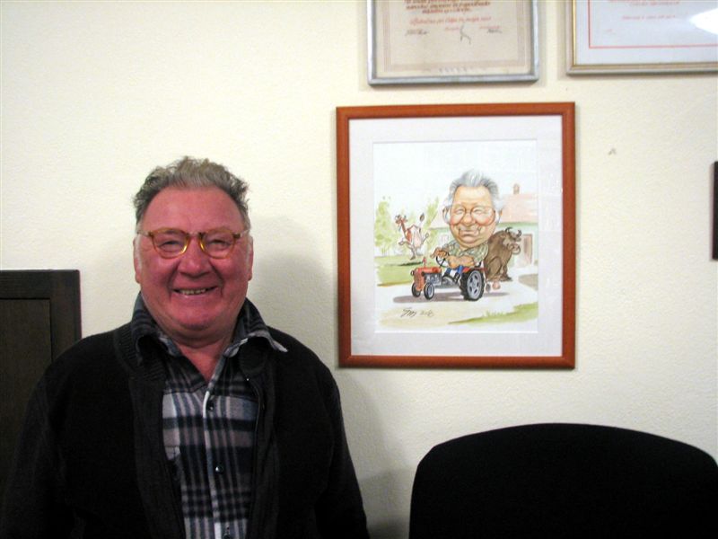 slavljenec s svojim portretom v ozadju